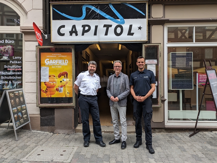 Polizeihauptkommissar Gerrit Racky, Dr. Dirk Götting, Leiter der Forschungsstelle für Polizei und Demokratiegeschichte, und Polizeikommissar Marvin Schories vor dem Capitol Kino in Hann. Münden.