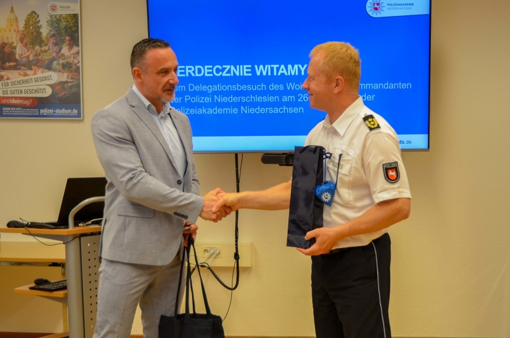 Zum Abschluss tauschen der Kommandant der Polizei der Woiwodschaft Niederschlesien, Paweł Póltorzycki (links), und der Akademiedirektor Carsten Rose Präsente aus.